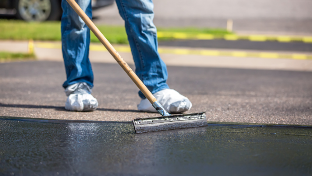 man sealing and coating asphalt pavement